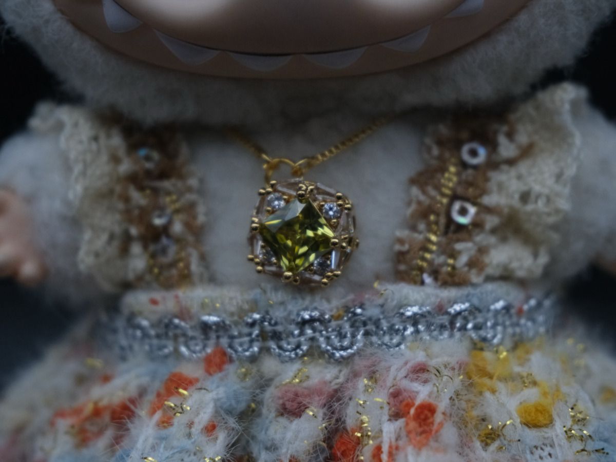 Close-up on The labubu figure's bridal outfit, showing the intricate details of the lace dress, and the necklace