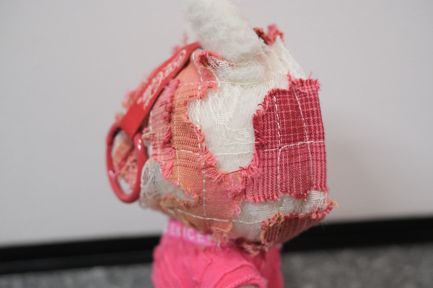 Close-up on The Monsters figure's textured pink hoodie,highlighting the unique fabric.