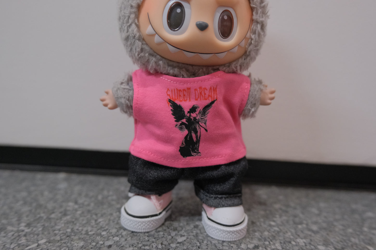 Close-up on The Monsters figure, highlighting the pink vest, jeans, and shoes.