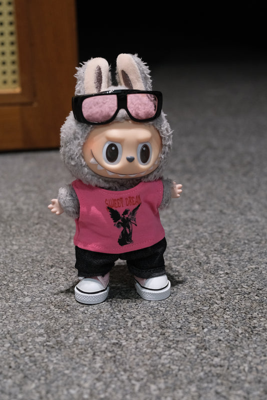 A Labubu figure wearing a 4-piece modern casual outfit, including a pink vest, denim jeans, dark sunglasses with a metallic frame, and white sneakers
