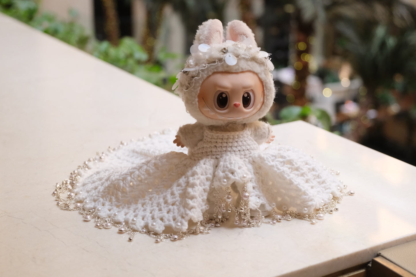 A Labubu figure wearing a white wedding dress with a lace bodice, full skirt, and a headband.