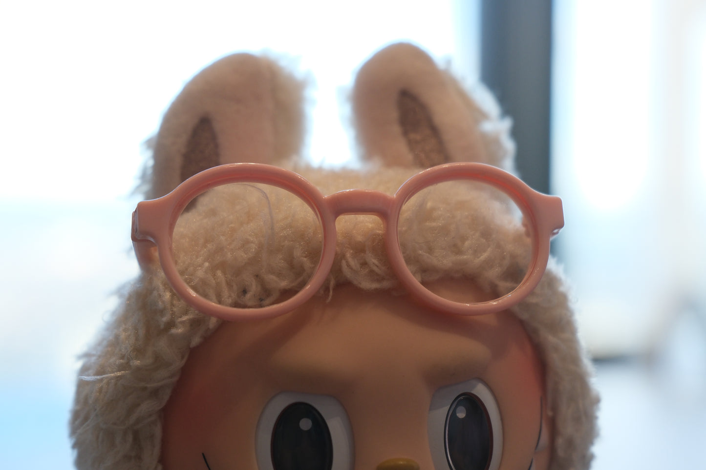 Front view of the Labubu figure showcasing the pink-rimmed glasses accessory.