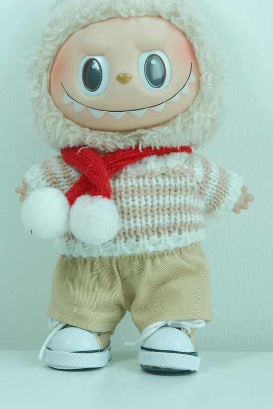 Close-up of The Monsters figure in the chunky knit sweater and layered plaid scarf