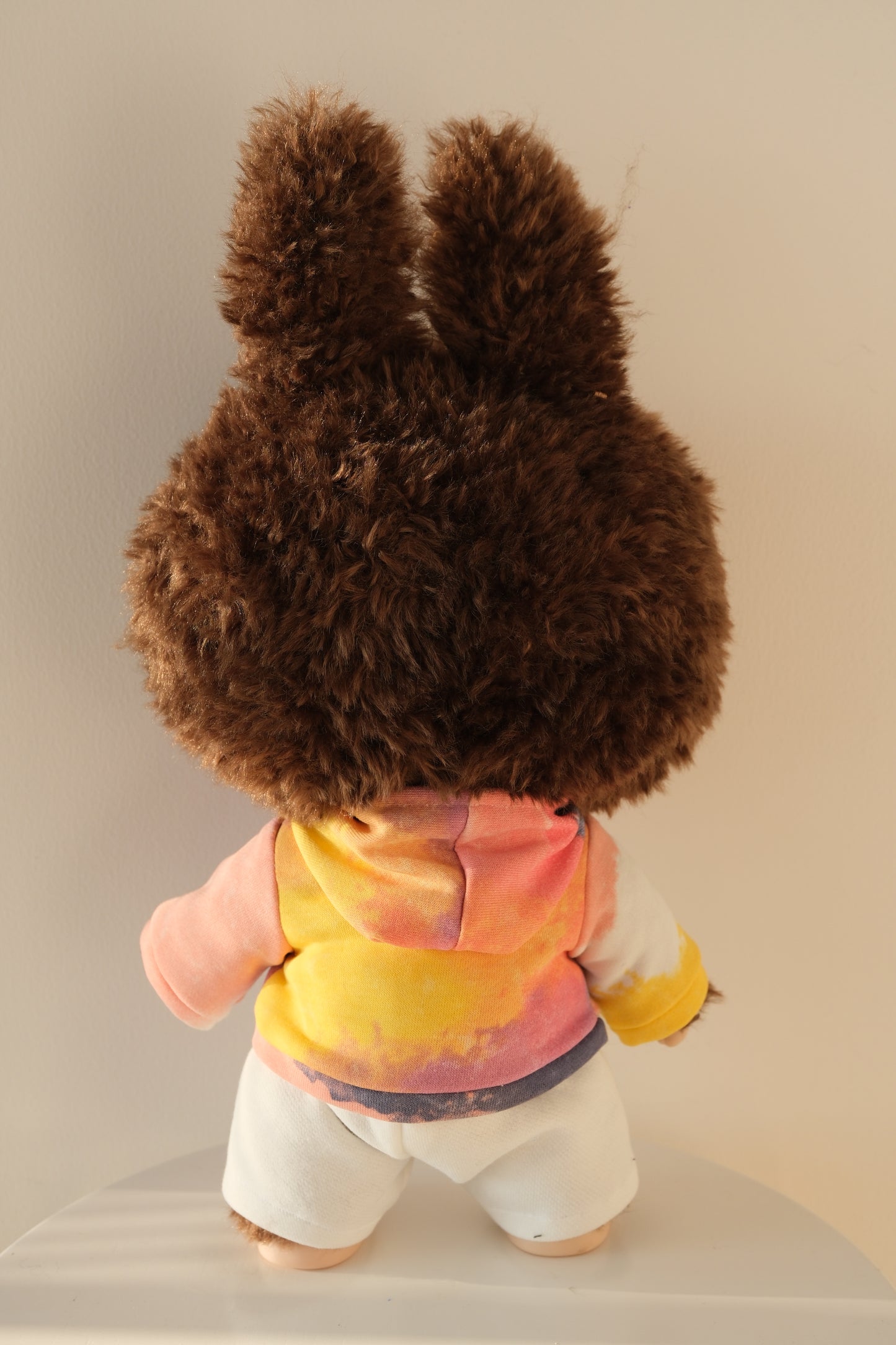 back view A 38cm Labubu figure wearing a vibrant gummy-colored neon hoodie and crisp white pants streetwear set