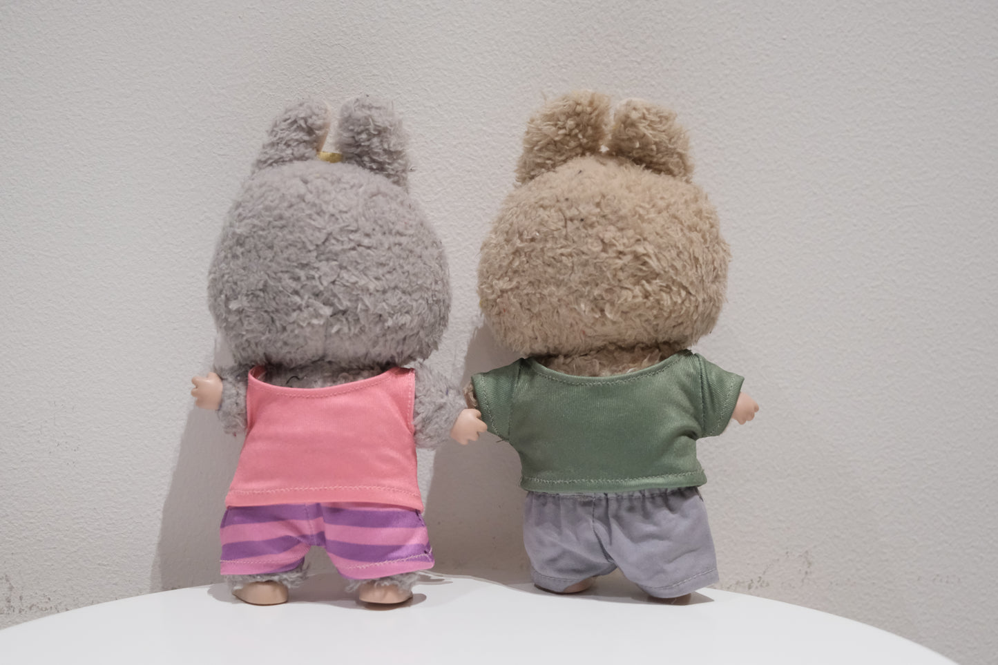 back view of Labubu figures wearing the 4-piece Judy Hopps (pink shirt, striped pants) and Nick Wilde (green shirt, grey pants) Zootopia costume set