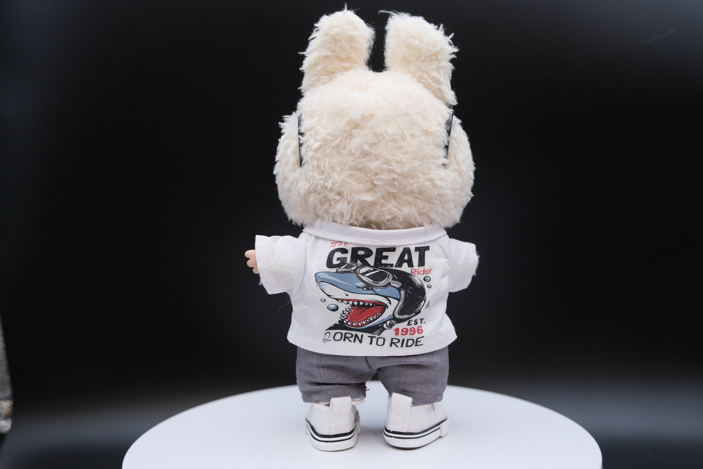 A Labubu figure wearing a 5-piece white outfit, including a shirt, sunglasses, necklace,shoes and pants.