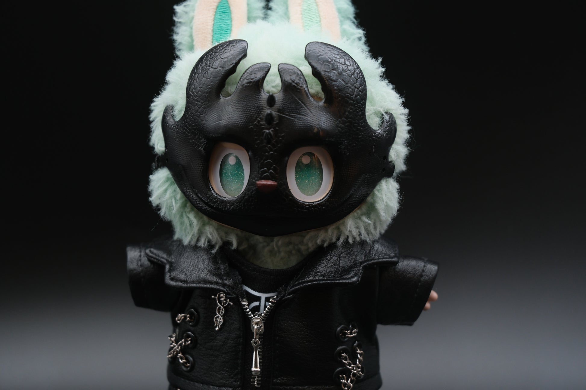 A Labubu figure wearing a 5-piece monster streetwear outfit, including a black leather jacket, jeans, and a scary mask.