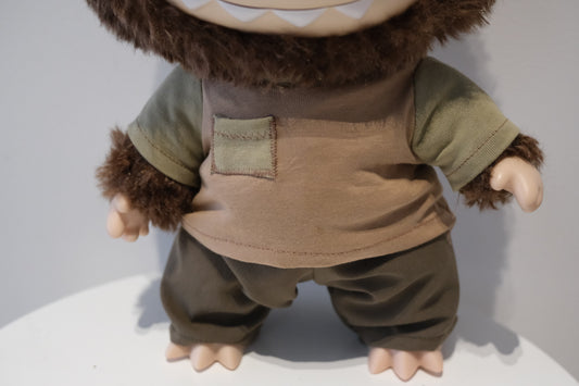 Labubu figure wearing a 2-piece reconstructed utility outfit from the Let's Checkmate series, featuring multi-shaded grey paneled pants and a graphic streetwear T-shirt.