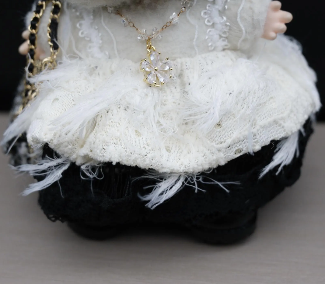 Close-up of a labubu with white lace dress and feathered skirt