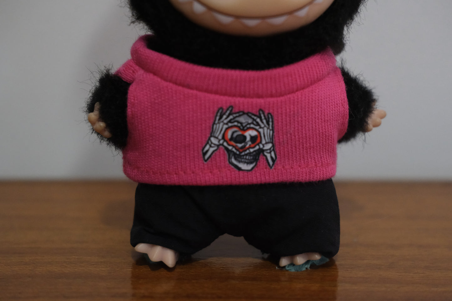 a close up of labubu pin for love pink sweater