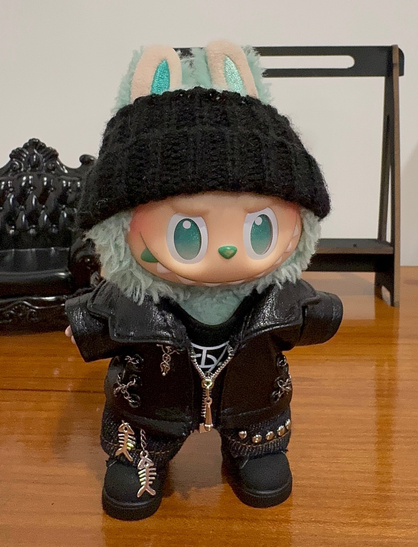 LABUBU plush doll wearing a black faux leather jacket with studs and a black beanie"