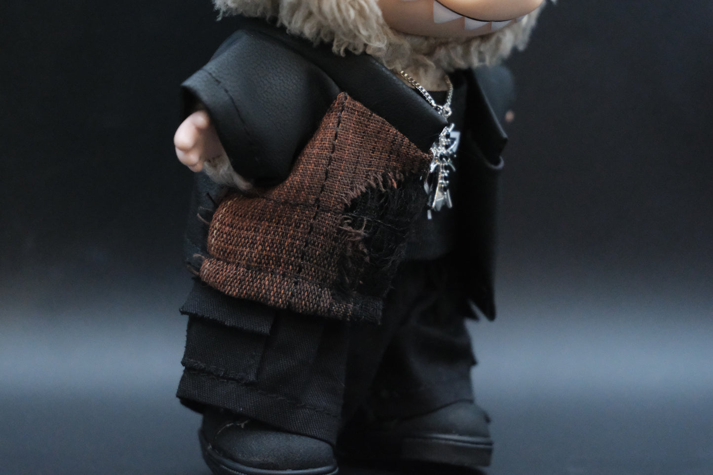 Side view of a Labubu figure wearing the full black and T-shirt outfit