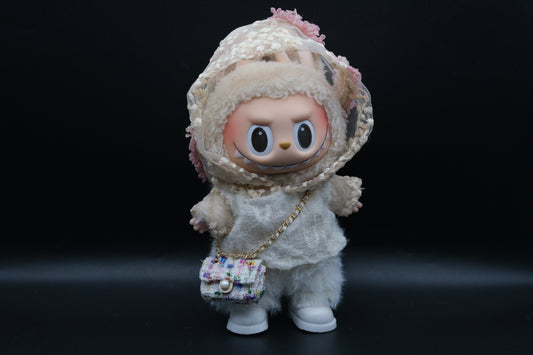 A Labubu figure wearing a white designer hoodie outfit, white pants and shoes, and a crossbody bag