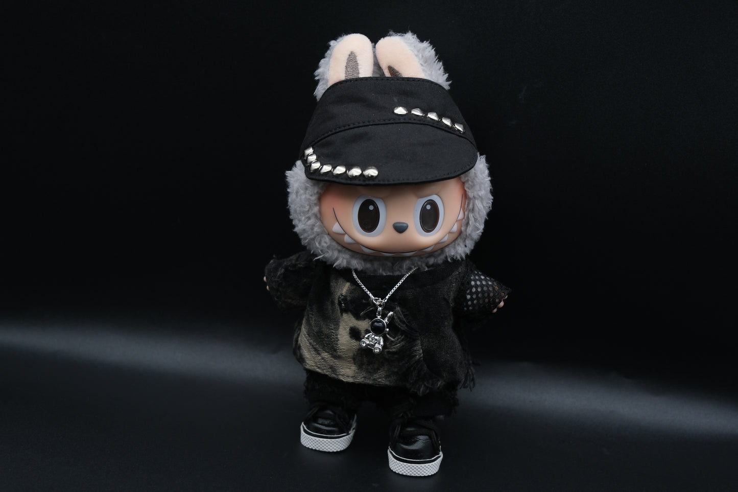 Labubu designer toy figure showcasing a modern streetwear look, featuring a punk hat , a black mixed dyeing distressed T-shirt, black pants and black sneakers and sliver necklace