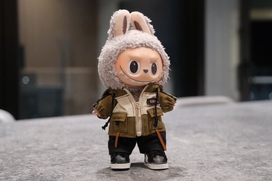 Labubu figure wearing a green and white mountaineering parka jacket, black pants, and black sneakers