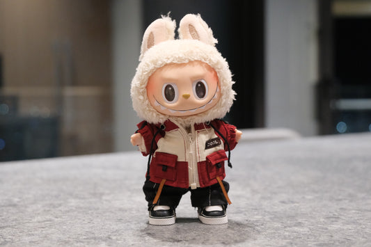 Labubu figure wearing a red and white mountaineering parka jacket, black pants, and black sneakers