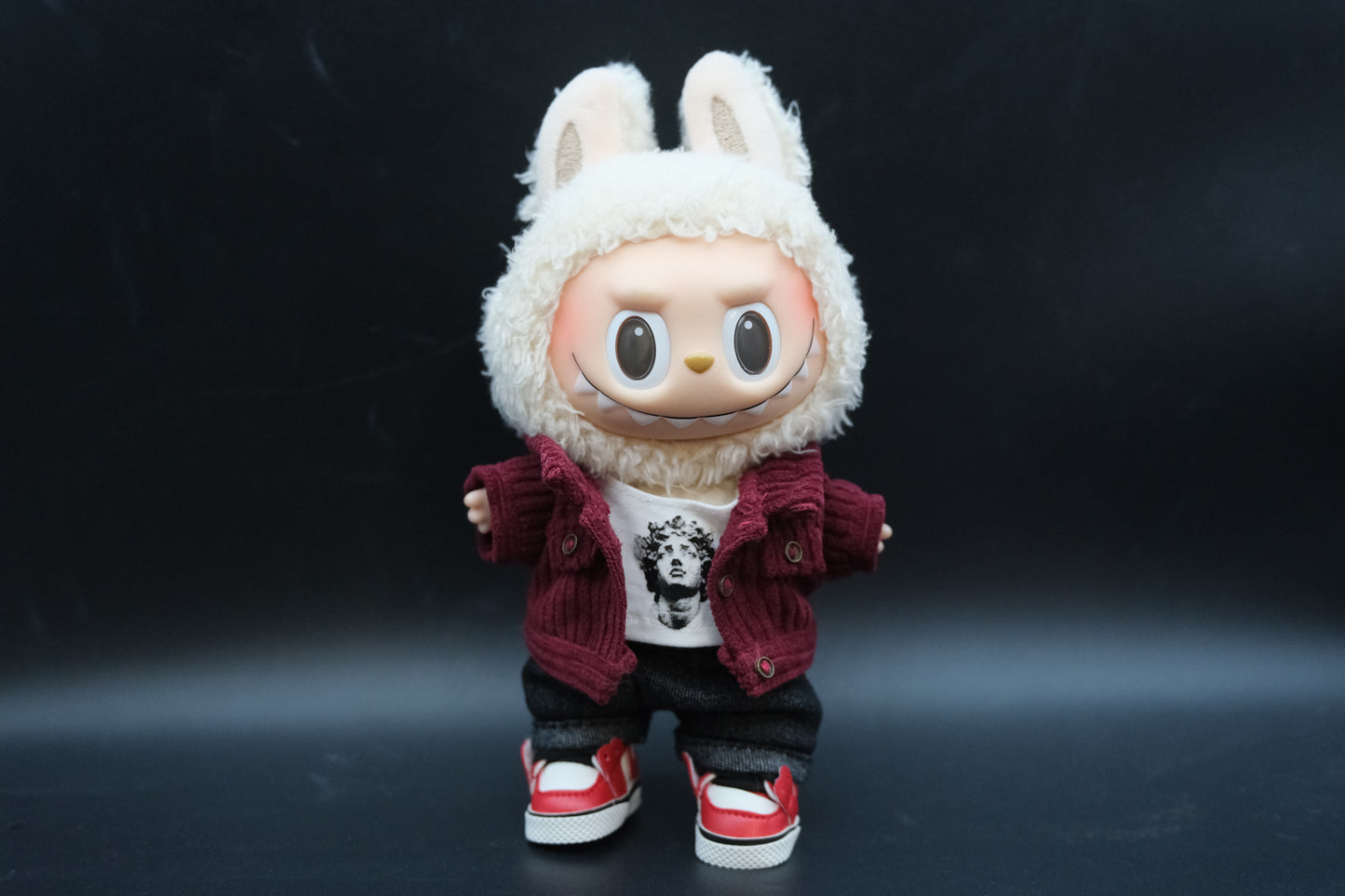 Labubu figure wearing a 4-piece tech-wear outfit with a studded nylon jacket ,t-shirt, jeans and sneakers