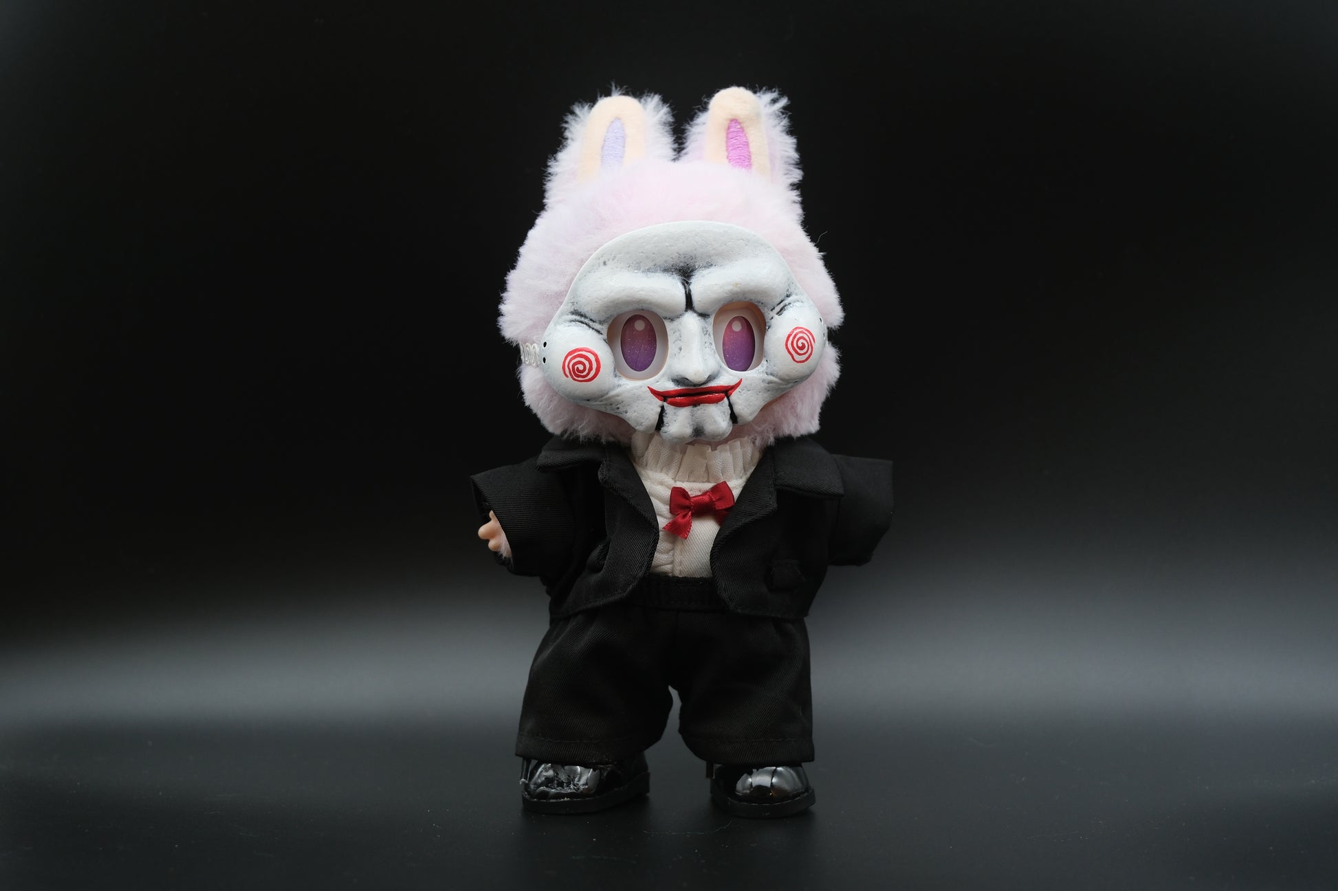 A Labubu figure wearing a 6-piece theatrical villain suit, including a plaid jacket, pants, and a creepy mask.
