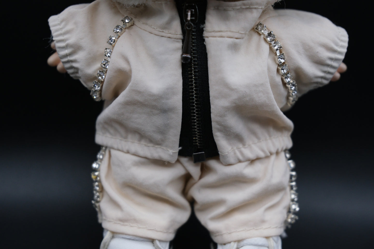 details of A Labubu figure wearing a white zippered jacket and white pants