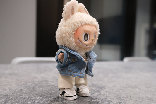 Labubu figure wearing a 5-piece outfit: light blue denim jacket, white tee, white leather shorts, sun necklace, and sneakers