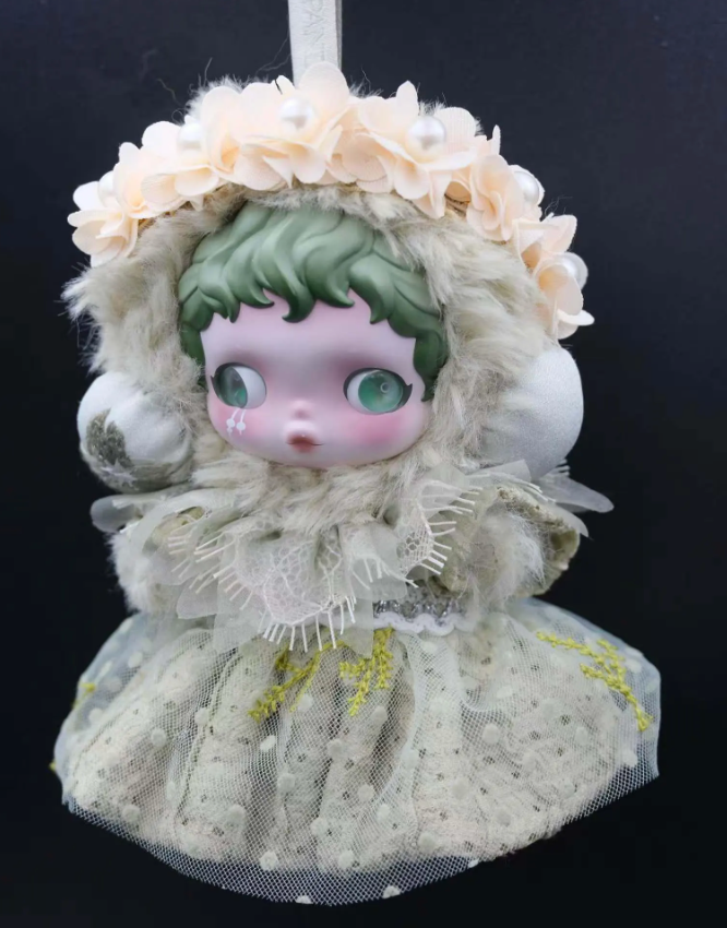A Skullpanda figure wearing a custom-made, mint-colored feather dress and a fluffy cap with lace trim