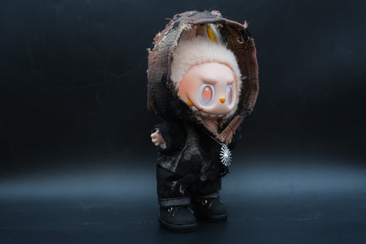 sideview of LABUBU plush doll wearing a distressed black hoodie and a silver sun pendant necklace