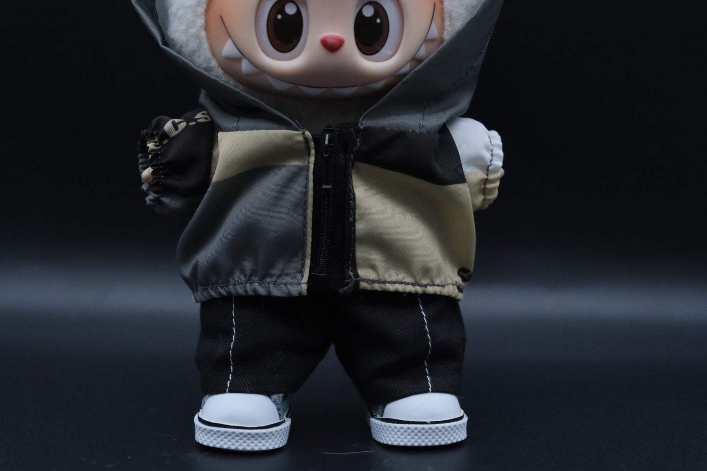 close up of outfit: a Labubu figure wearing a functional windbreaker outfit, black pants and shoes