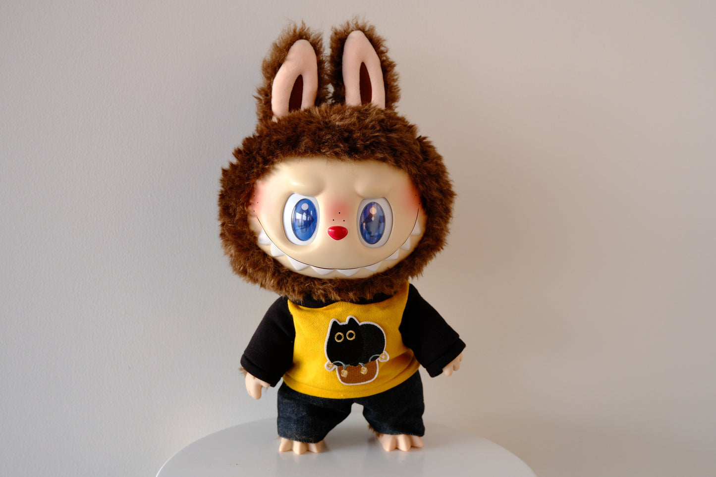 Front view of 38cm Labubu figure wearing a blue Let's Checkmate series hoodie and structured denim jeans.