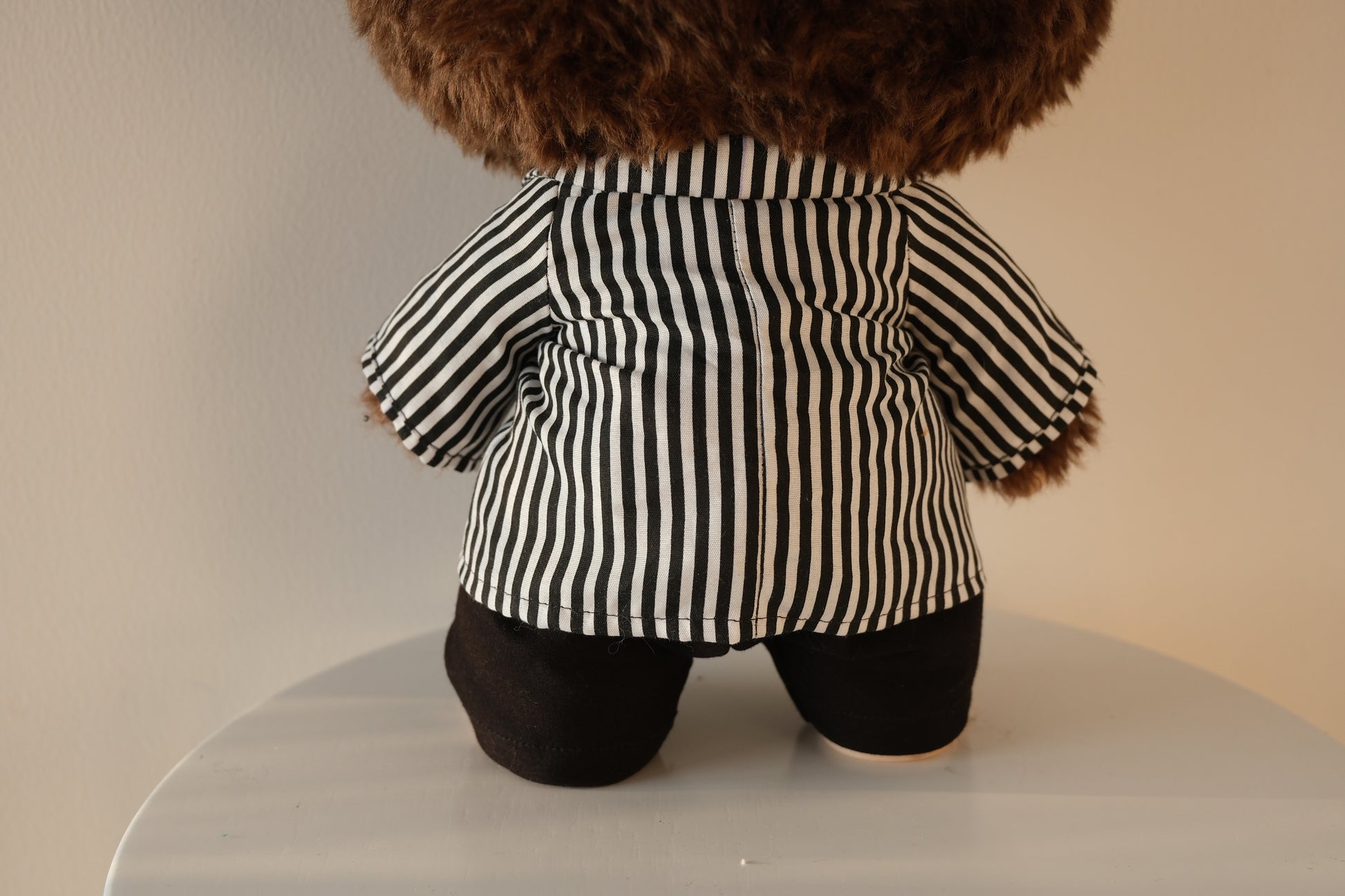 back view of 38cm Labubu wearing a black and white striped shirt and black tailored pants set