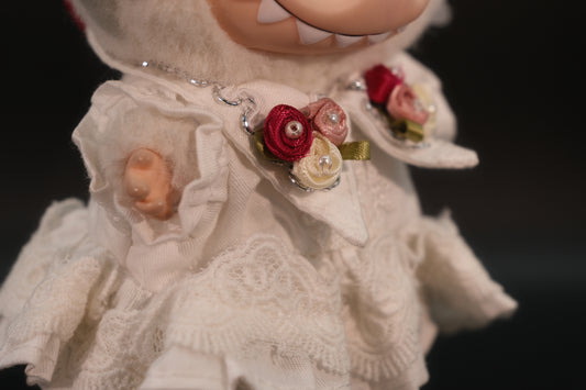 A clode-up of full body shot of the Labubu figure wearing the complete white dressoutfit