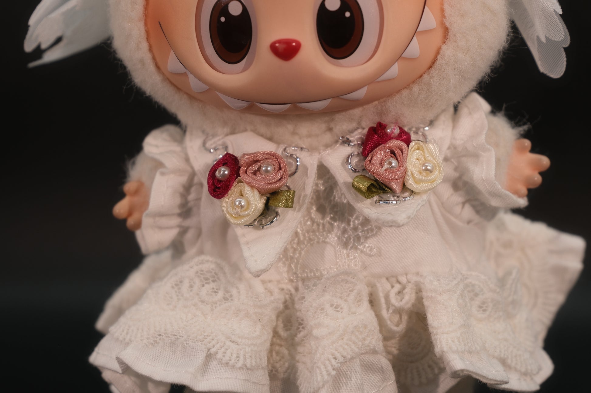 A close-up of  full body shot of the Labubu figure wearing the complete white dressoutfit