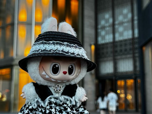 a close-up of labubu black hat,sliver necklace and french black and white dress

