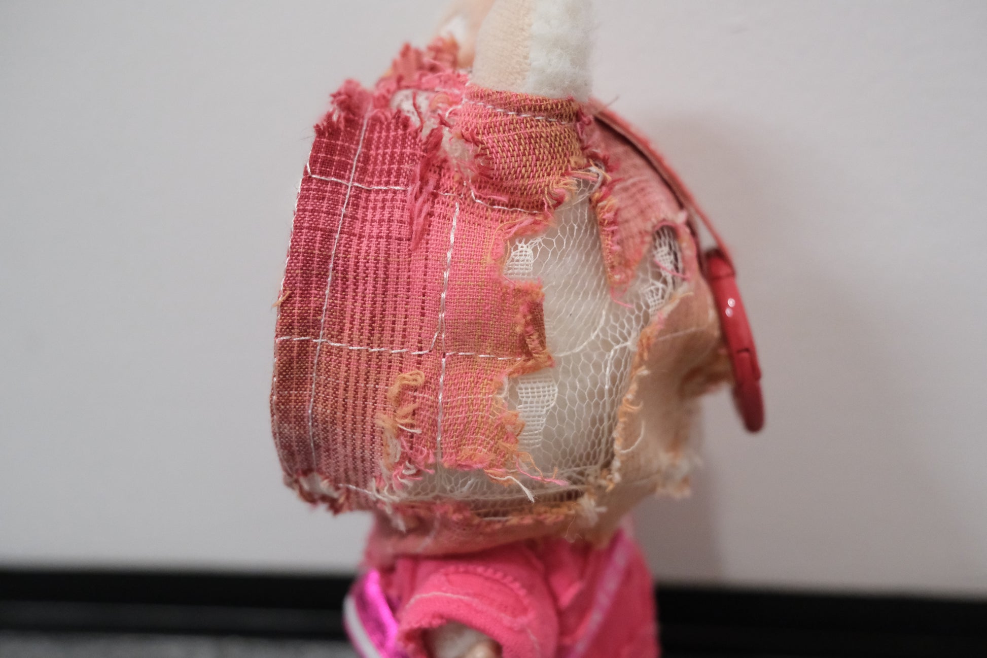 Close-up on The Monsters figure's textured pink hoodie, highlighting the unique fabric.