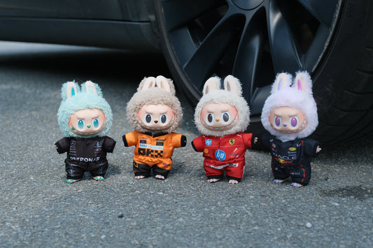 A collection of four LABUBU dolls wearing handmade F1 team uniforms from Mercedes, McLaren, Ferrari, and Red Bull Racing.