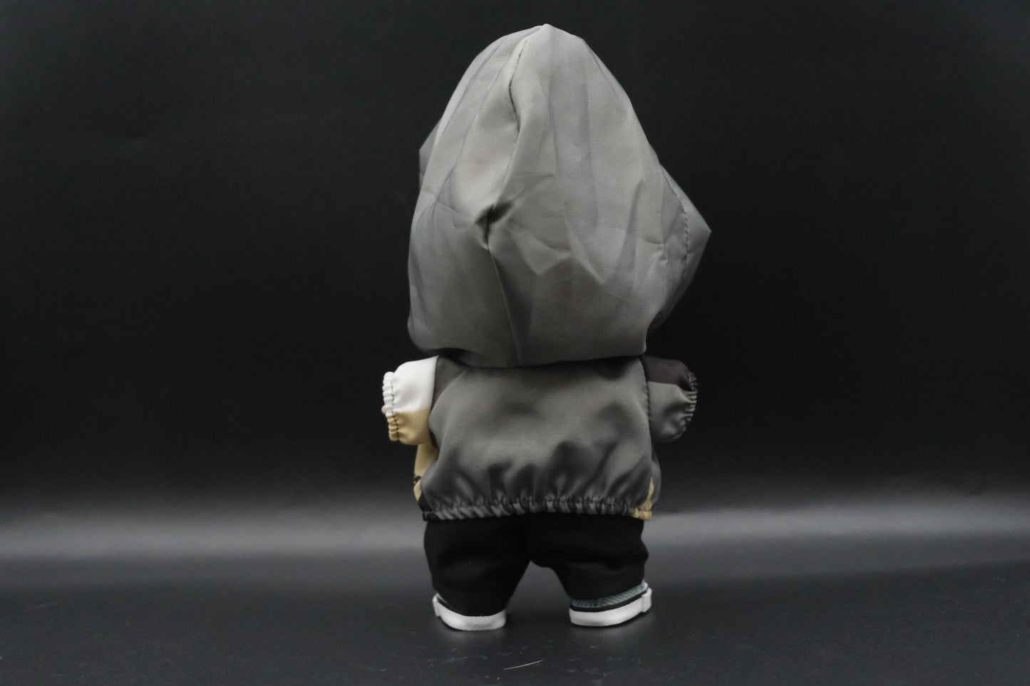  a back view of Labubu figure wearing a functional windbreaker outfit, black pants and shoes