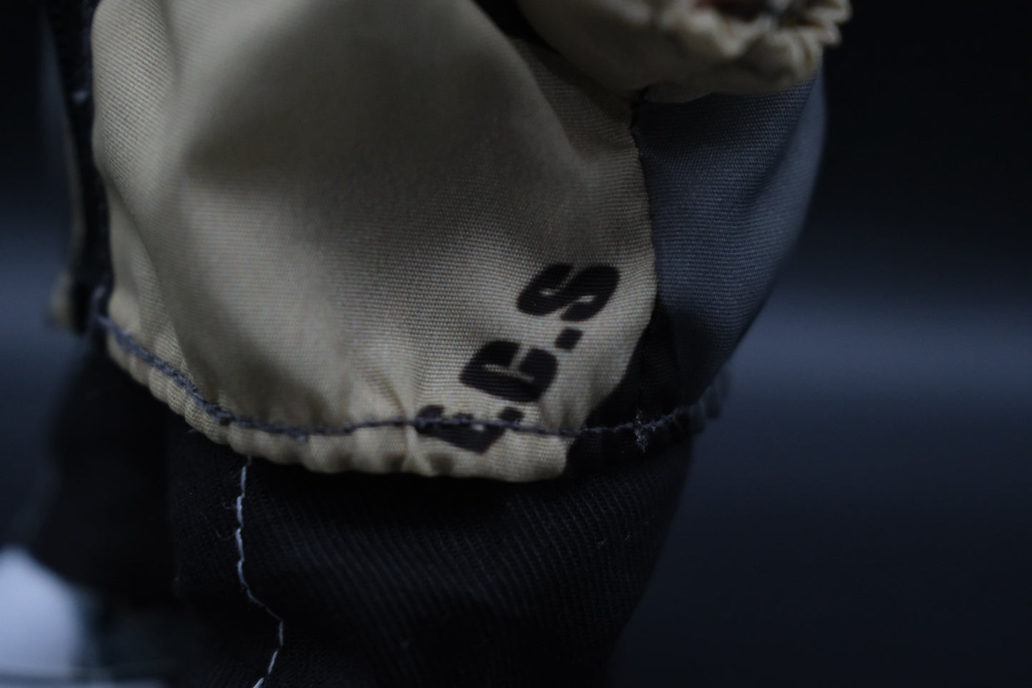  a close up details of  Labubu figure wearing a functional windbreaker outfit and show “ECS" logo