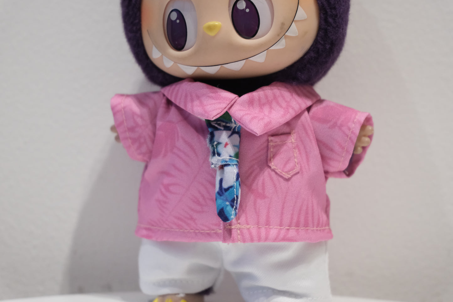 Close-up of The labubu  figure in the Nick Wilde inspired striped tie and collared shirt
