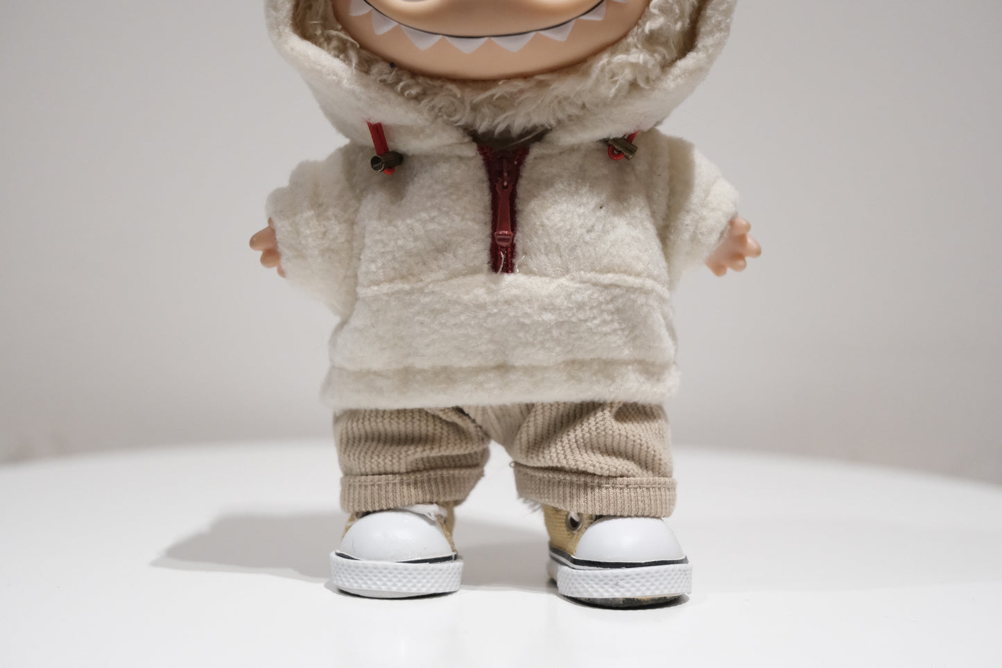Labubu figure wearing a 3-piece teddy fleece hoodie and pants cozy winter outfit with white sneakers.
