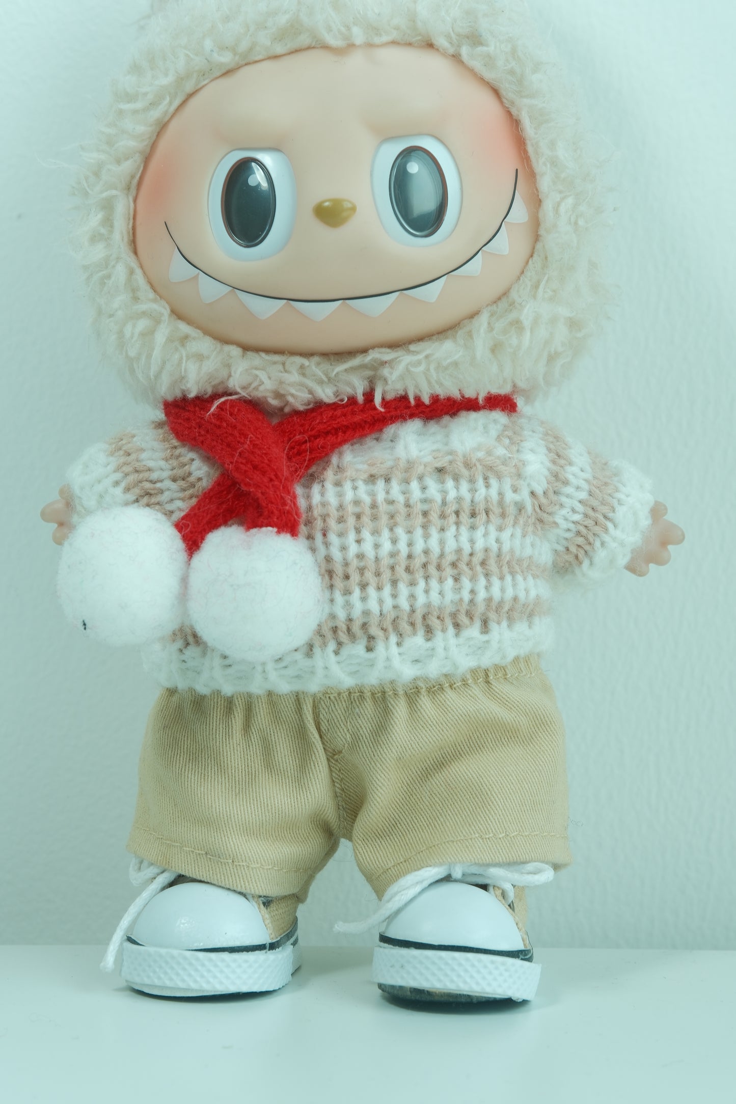 Close-up of The Monsters figure in the chunky knit sweater and layered plaid scarf