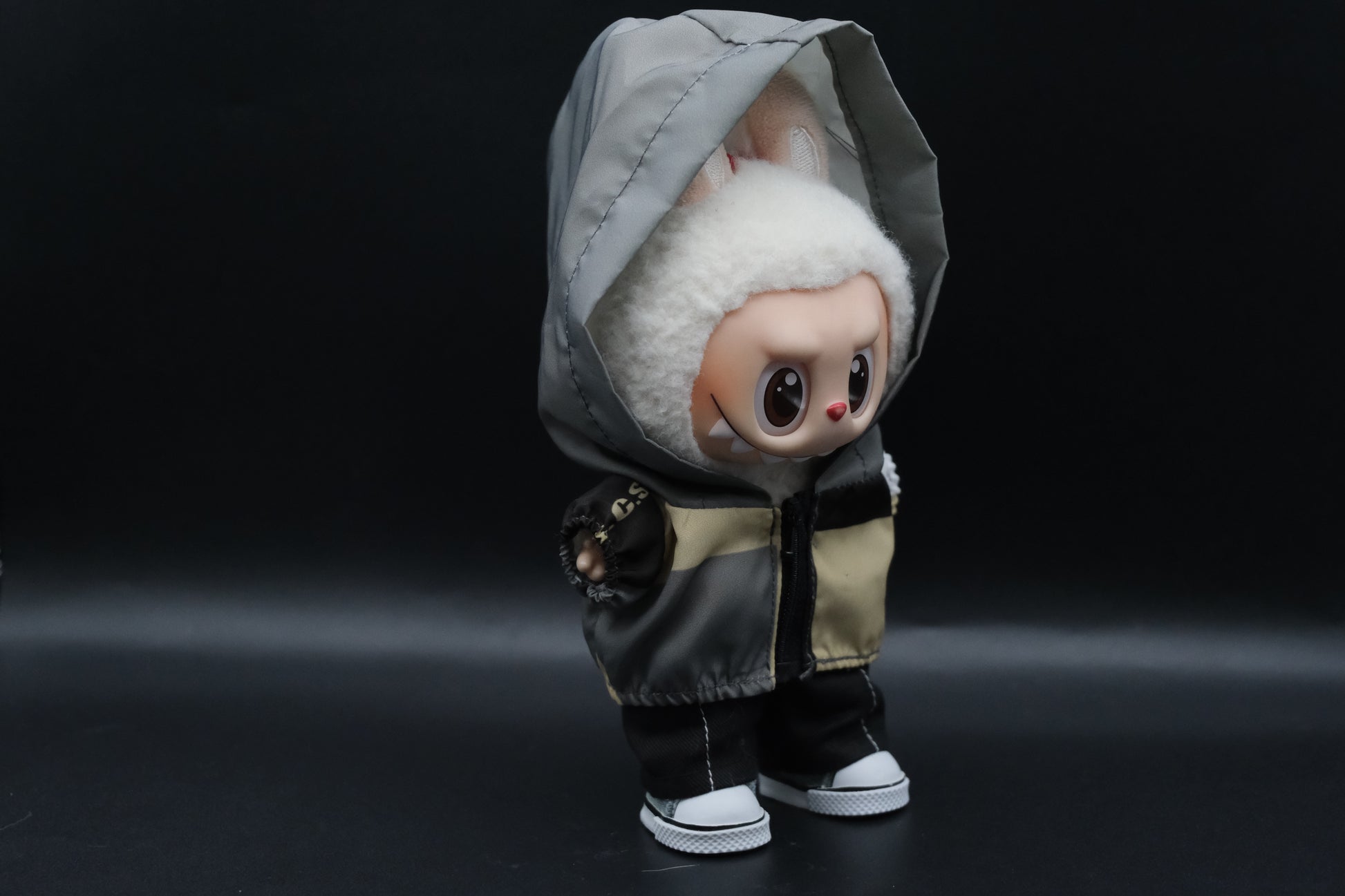  a side view of Labubu figure wearing a functional windbreaker outfit, black pants and shoes