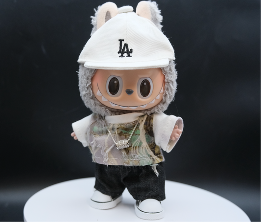 A Labubu figure wearing a streetwear outfit with a distressed camouflage T-shirt, a white LA baseball cap, and white sneakers