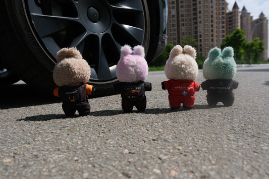 back view of  A collection of four LABUBU dolls wearing handmade F1 team uniforms from Mercedes, McLaren, Ferrari, and Red Bull Racing.