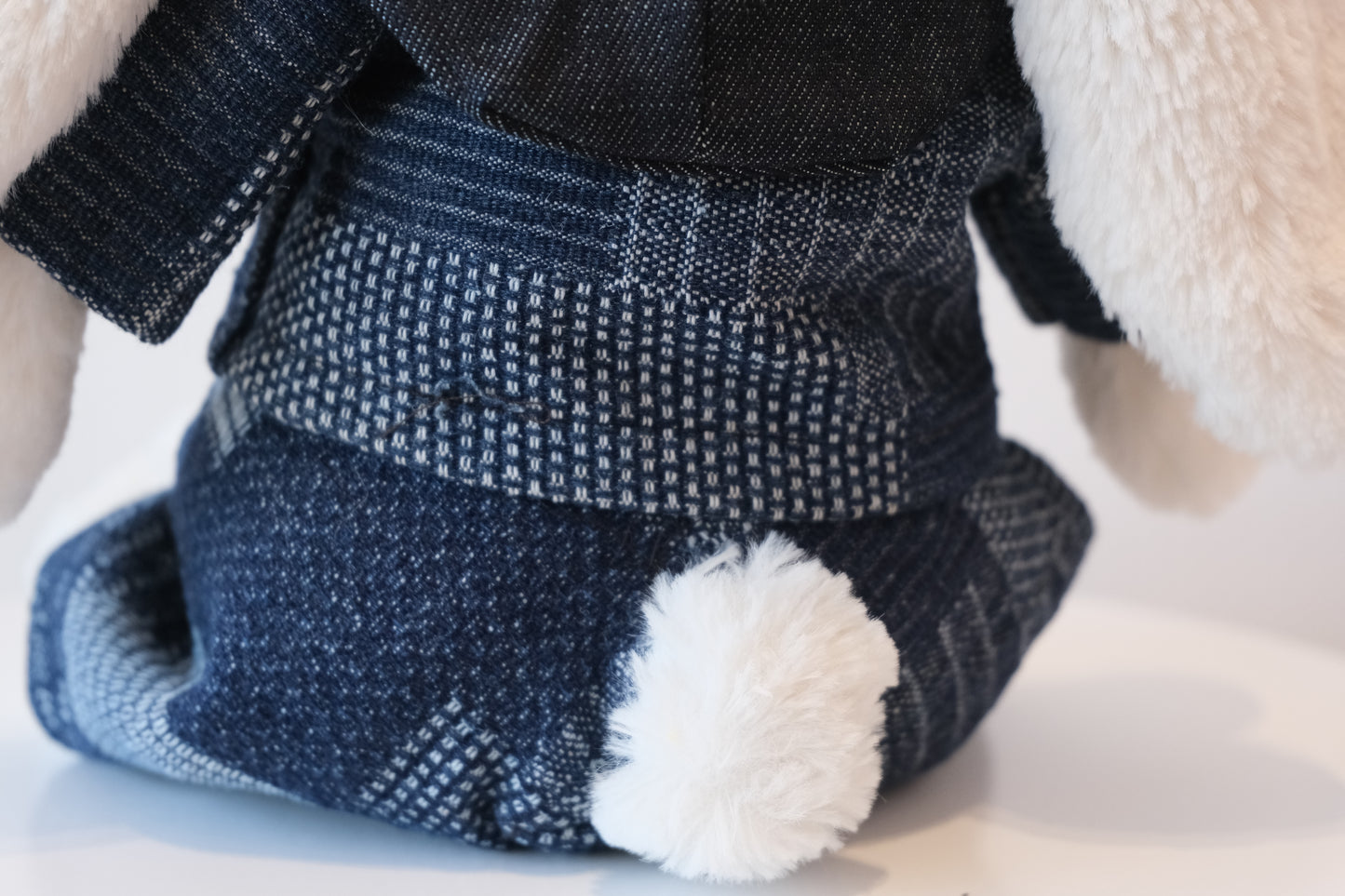 Close-up of unique geometric woven pattern on indigo fabric of the Jellycat Bunny outfit