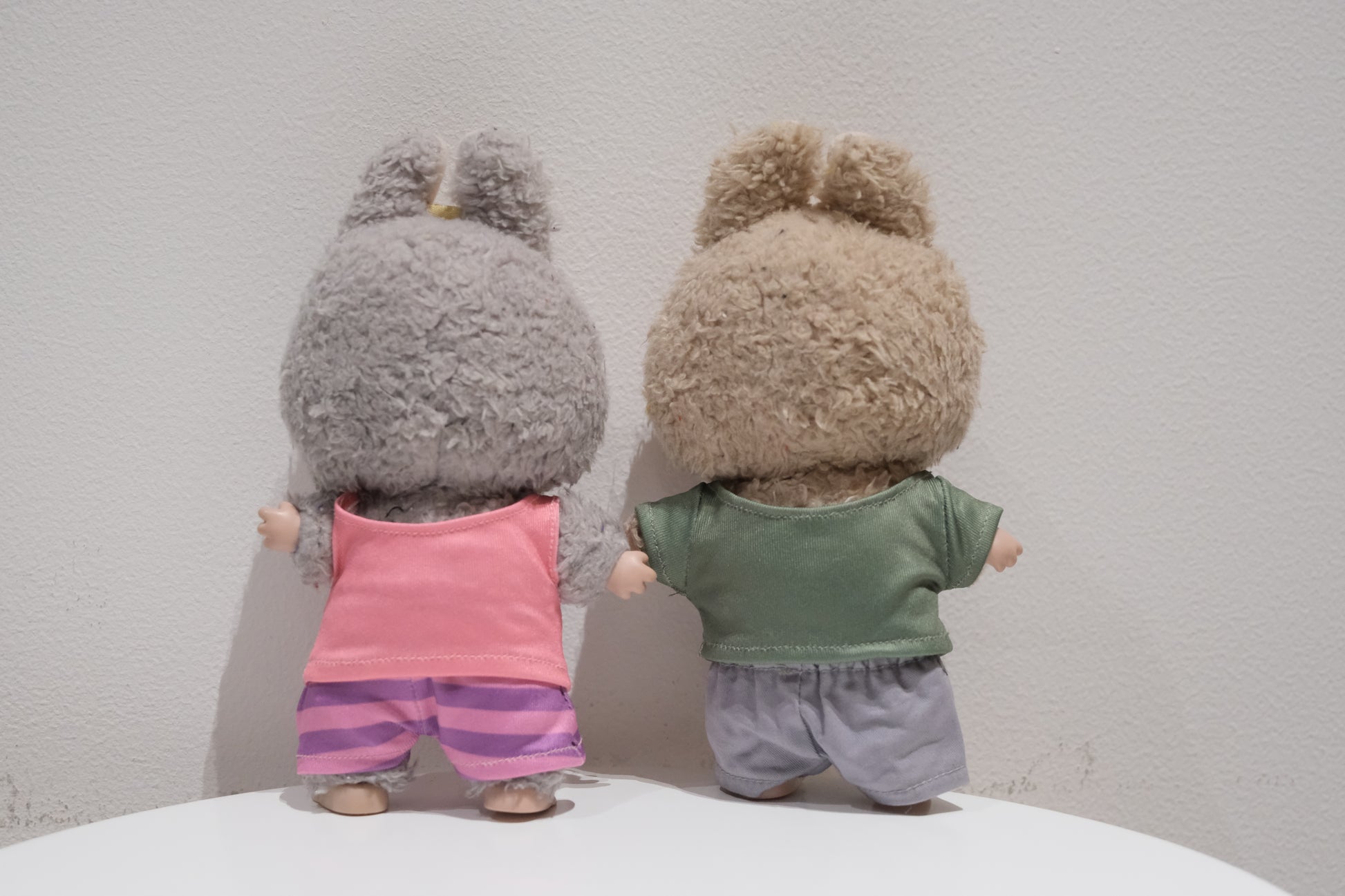 back view of Labubu figures wearing the 4-piece Judy Hopps (pink shirt, striped pants) and Nick Wilde (green shirt, grey pants) Zootopia costume set