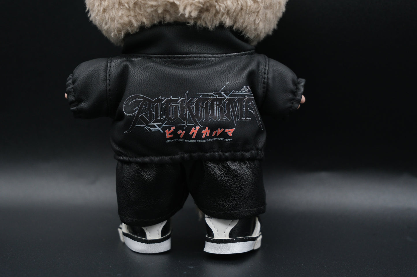 A Labubu designer toy figure in a dark, urban-style outfit, featuring a black leather jacket and pants , sunglasses and a pair of shoes