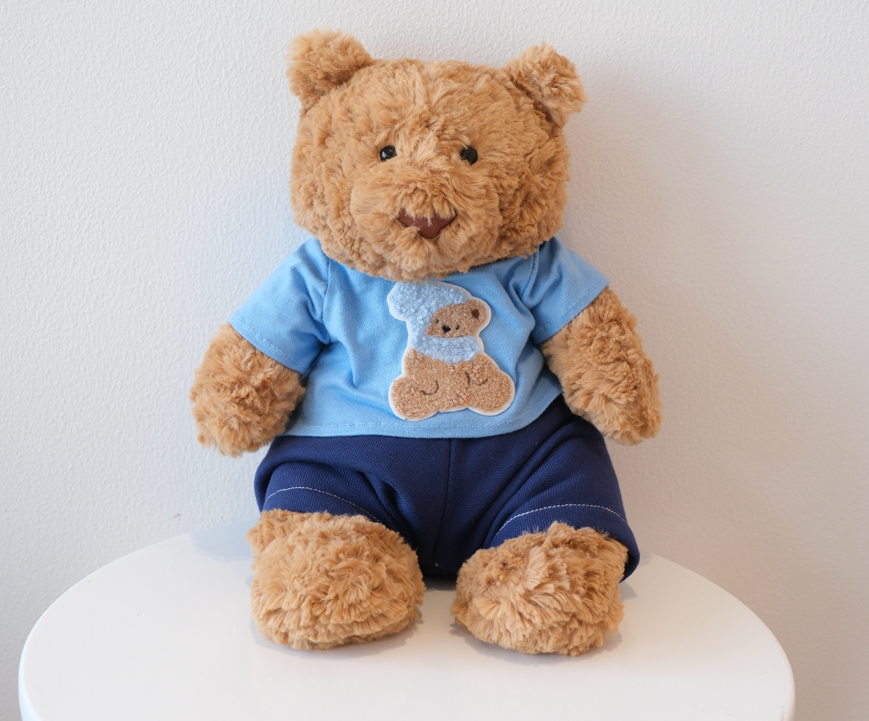 Jellycat Bartholomew Bear wearing a 2-piece cozy casual outfit with a miniature T-shirt and matching pants.