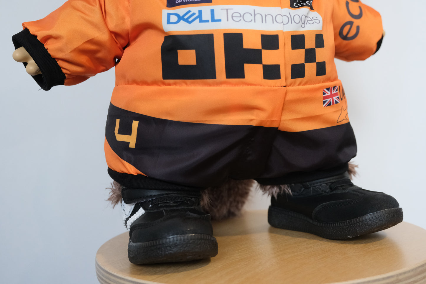 58cm Mega Zimomo wearing a McLaren F1 racing jumpsuit in orange and black