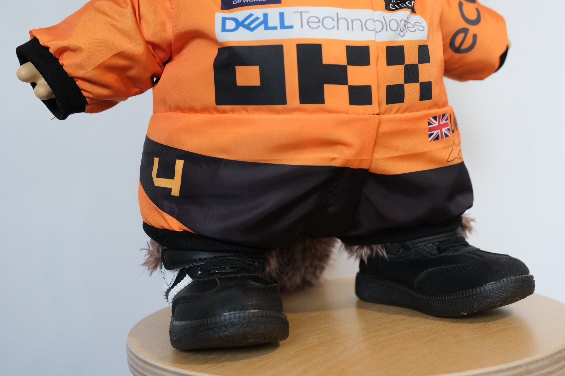 58cm Mega Zimomo wearing a McLaren F1 racing jumpsuit in orange and black