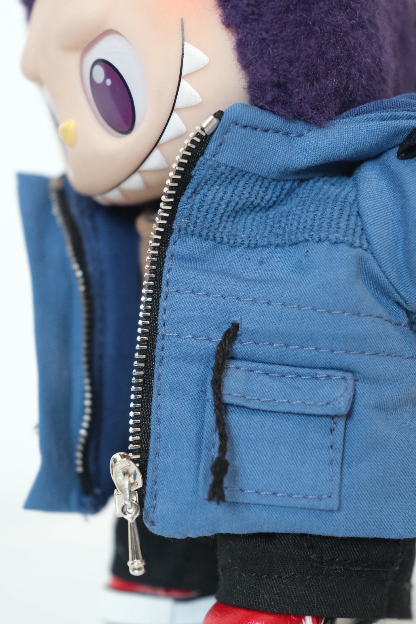 A Labubu figure dressed in a 4-piece blue winter mountaineering outfit, including a utility parka with a 'COOL' patch, black pants, and white sneakers.