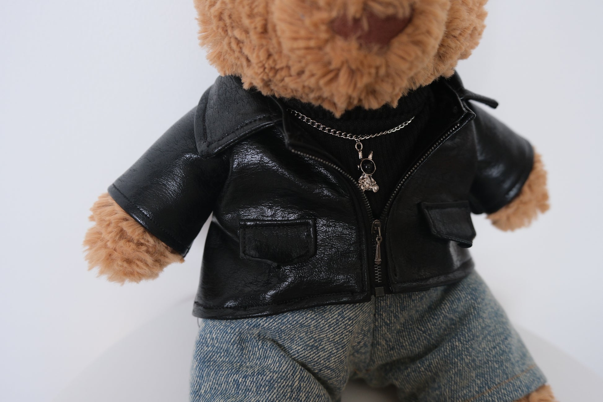 Close-up detail of the faux leather texture and miniature collar on a punk-style jacket for a Jellycat Bear.